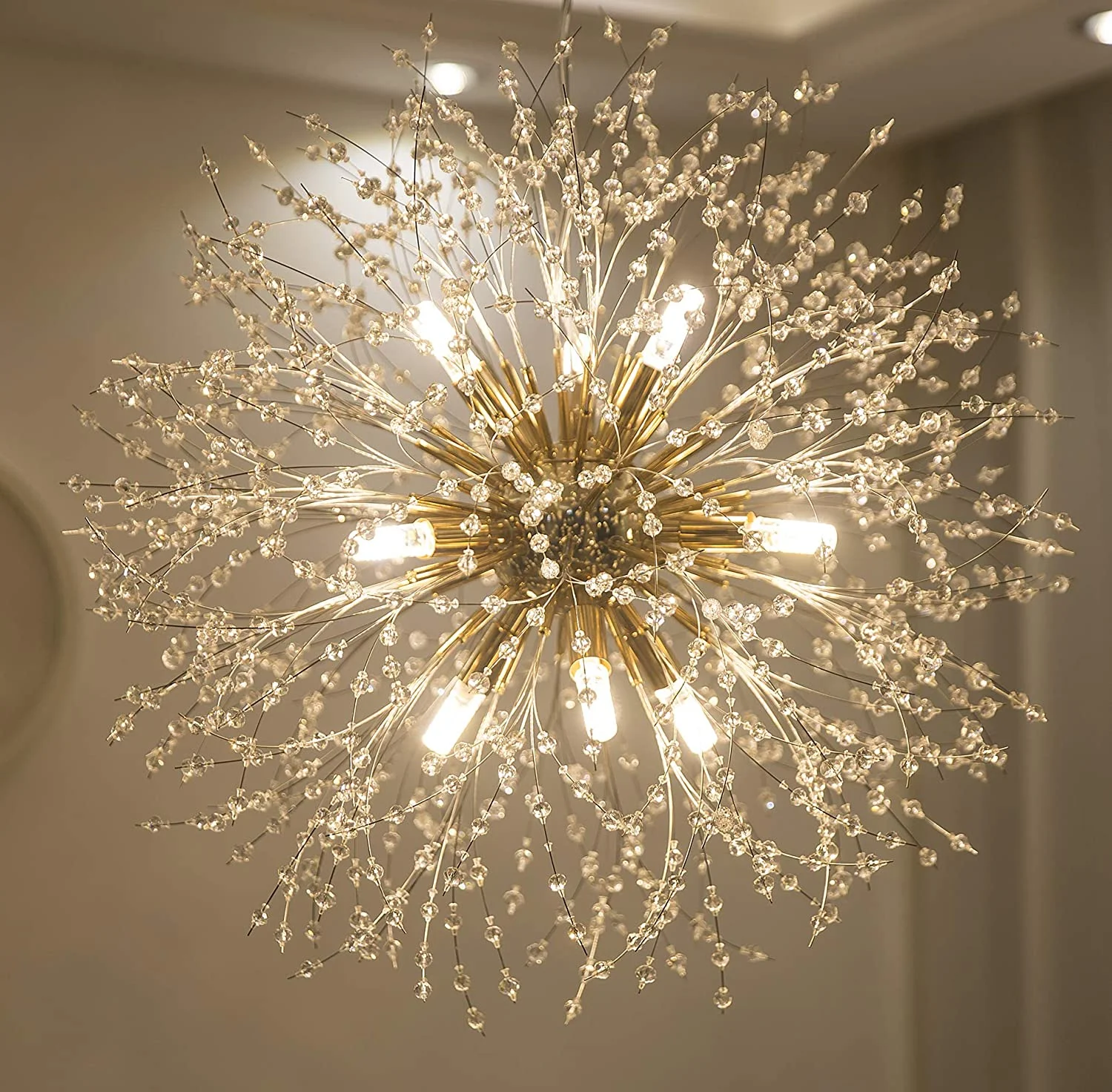 Electrician installing ceiling light fixture in residential room